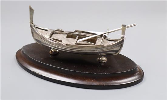 An early 20th century Maltese white metal model of a Dghjasa, with two oars, on stand, 3.5 oz.